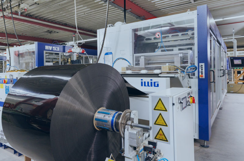 Rolle mit Rohmaterial an der Maschine zur Rollenformung